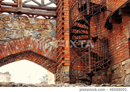 A winding spiral staircase used as fire escape in old gothic bri A winding spiral staircase used as fire escape in old gothic bri 46088091
