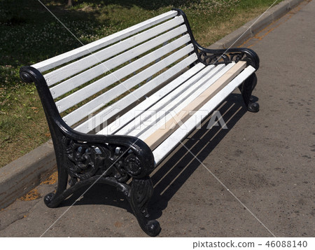 White wooden bench in the park on the street. 46088140