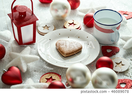 Christmas plate with homemade gingerbread snowflakes baubles and red lantern on a white table. 46089078