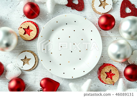 Christmas decoration with a white plate in golden dots and snowflakes on a white table. 46089131