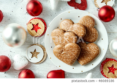 Christmas plate with homemade gingerbreads star baubles on a white table. 46089186