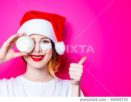 Woman using eye patch for her eyes in Santa Claus hat Woman using eye patch for her eyes in Santa Claus hat 46089730