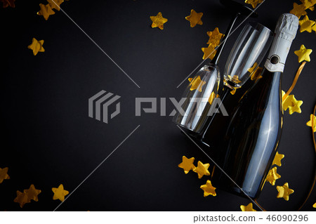 Glasses and bottle of champagne with golden serpentines and confetti Glasses and bottle of champagne with golden serpentines and confetti 46090296