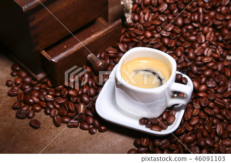 Fresh roasted coffee beans in burlap sack, coffee cup and grinder on dark background. Fresh roasted coffee beans in burlap sack, coffee cup and grinder on dark background. 46091103