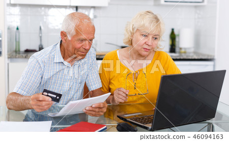 Smiling mature family couple with banking card near laptop 46094163