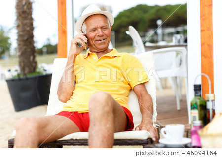 Positive mature man sitting and speaking phone 46094164