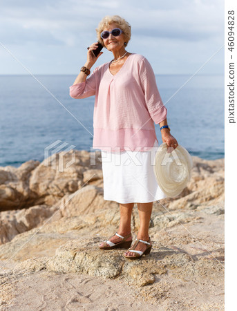 Aged woman talking on phone outdoors 46094828