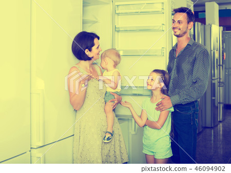 family of four shopping new refrigerator in home appliance store family of four shopping new refrigerator in home appliance store 46094902
