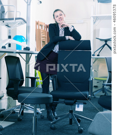 Saleswoman standing in chair store Saleswoman standing in chair store 46095378