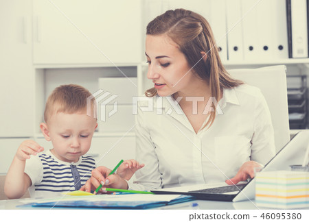 Girl is working on laptop while kid painting on papers Girl is working on laptop while kid painting on papers 46095380