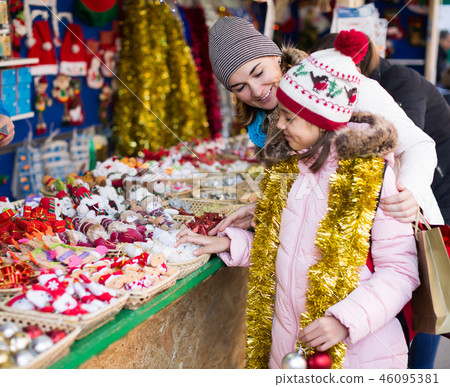 Positive woman with small daughter in market Positive woman with small daughter in market 46095381