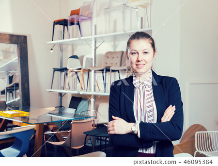 Saleswoman standing in chair store 46095384