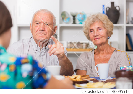 Serious mature parents having unpleasant talk with daughter 46095514