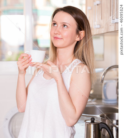 Sporty girl is standing and drinking tea 46095824