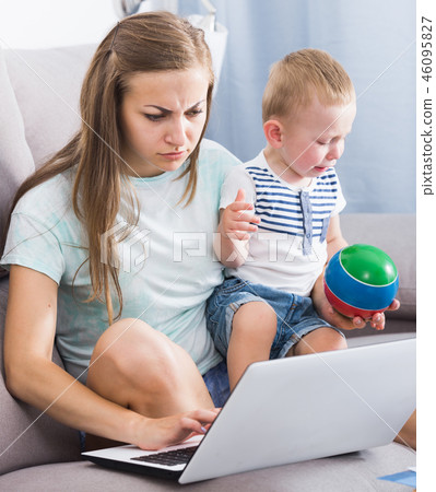 Female is having problems with kid while working Female is having problems with kid while working 46095827