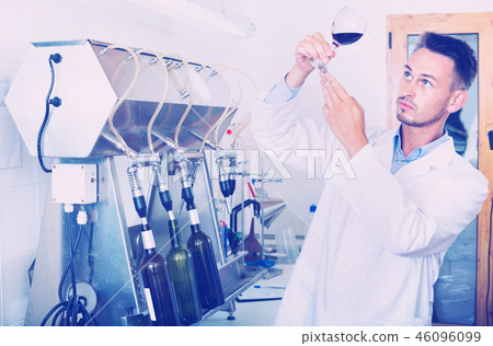 Portrait of male winery worker with bottling machinery on factor 46096099
