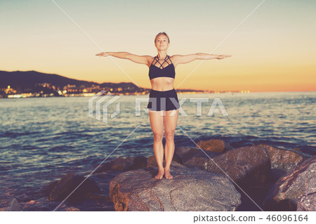 Woman is practicing stretching Woman is practicing stretching 46096164
