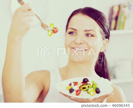 Woman holding fork and plate 46096345