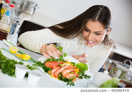 Girl decorating prepared dish of shrimps 46096459