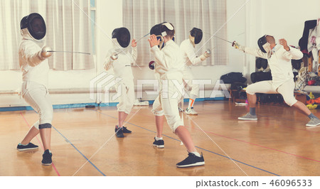 Boys and adults practicing fencing techniques 46096533