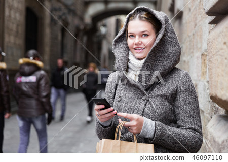 positive girl teenager with phone in hood 46097110