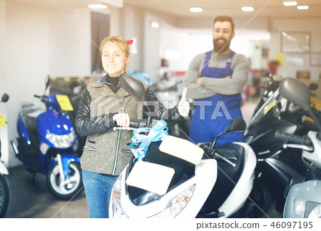 Worker with woman customer in motorcycle workplace 46097195