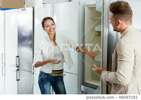 Young assistant in the shop sell a fridge 46097291