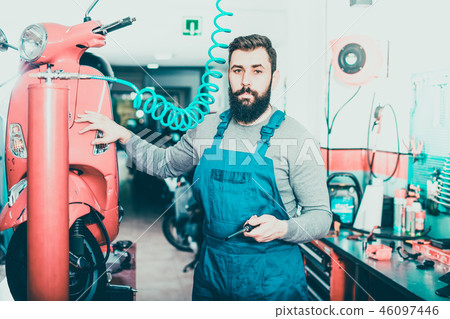 Positive male worker fixing failed motorbike 46097446