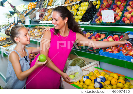 woman with girl buying apples 46097450