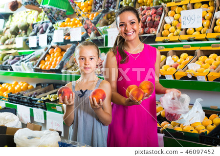 woman with girl buying peaches 46097452