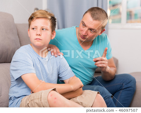Adult male with his anxious son are resting together and talking about teenage secrets 46097507