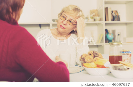 females talking at home with cup of tea females talking at home with cup of tea 46097627