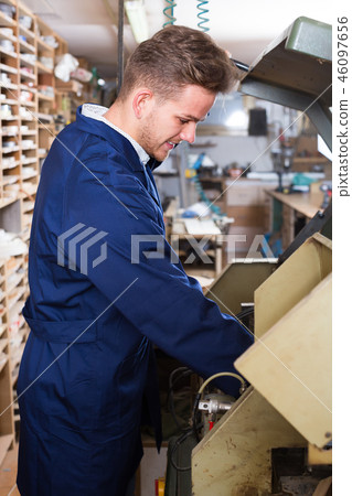 Young woodworker working with trimming machine 46097656