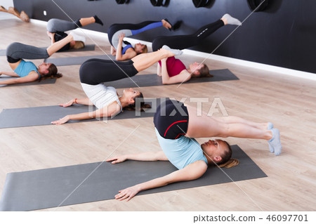 Females practicing yoga in studio Females practicing yoga in studio 46097701