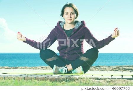 Positive young girl exercising on exercise mat Positive young girl exercising on exercise mat 46097703