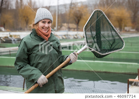 Woman with landing net on fish farm Woman with landing net on fish farm 46097714