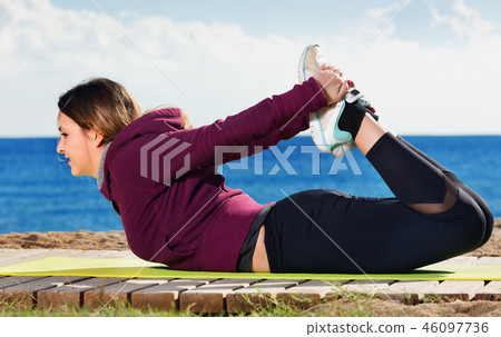 Young woman doing youga at beach Young woman doing youga at beach 46097736