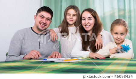 parents with little children buying insurance and smiling 46098424