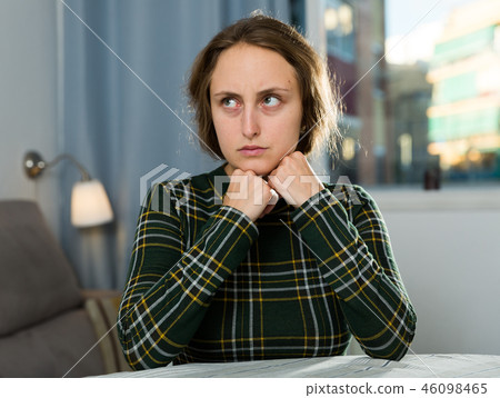 Portrait of sorrowful woman sitting at home 46098465