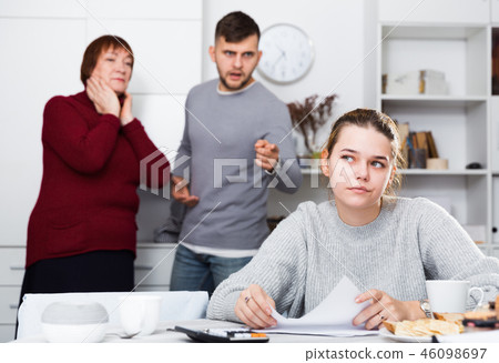 Frustrated woman with papers and discontented family 46098697