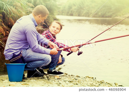 father and son fishing together on lake . father and son fishing together on lake . 46098904