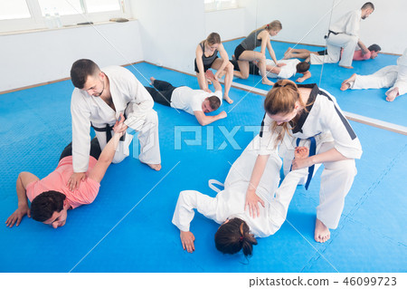 trainees sparring in pairs to practice new holds in taekwondo class 46099723
