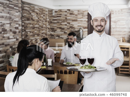 Chef taking care of adults at cafe table 46099748