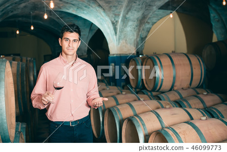 young man posing in winery cellar young man posing in winery cellar 46099773