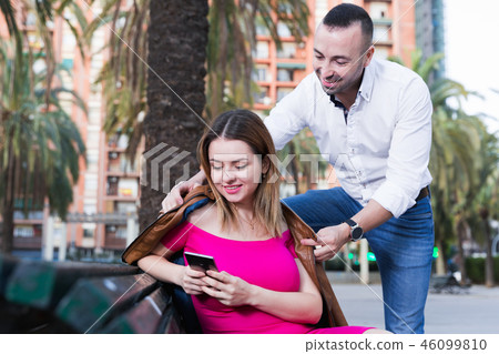 Girl is sitting with phone and inaccessibility for stranger man Girl is sitting with phone and inaccessibility for stranger man 46099810