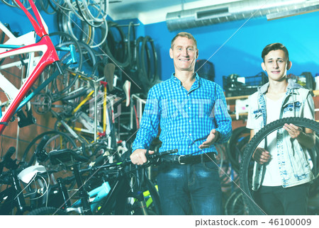 Man and teenage boy choosing new wheel 46100009
