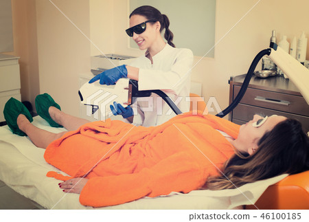female client doing laser hair removal from legs female client doing laser hair removal from legs 46100185