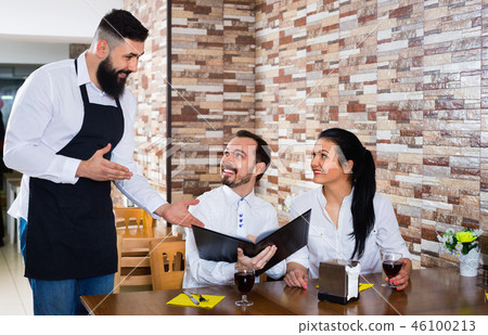 Waiter serving rural restaurant guests at table Waiter serving rural restaurant guests at table 46100213
