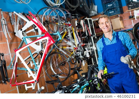 male seller fixing bike in bike store. 46100231