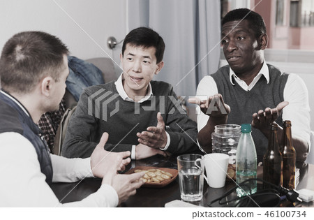 Three men are drinking beer and talking about life in time rest together 46100734
